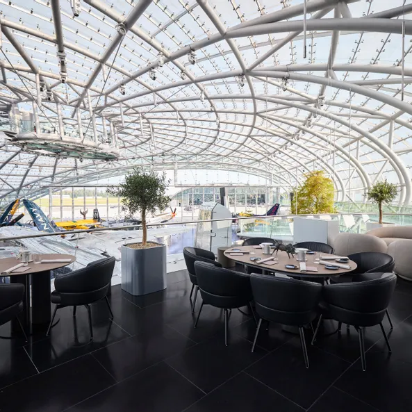 Gedeckte Tische auf der Restaurant Ikarus Terrasse mit Blick in die Austellung